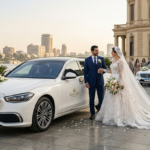 عروسان بجانب سيارة مرسيدس بيضاء فاخرة مزينة بالزهور لخدمة إيجار سيارات زفاف من رويال كايرو ليموزين في مصر.